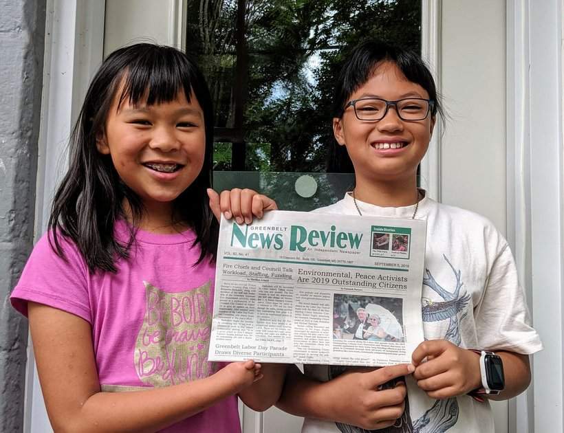 Greenbelt News Review held up by two girl carriers